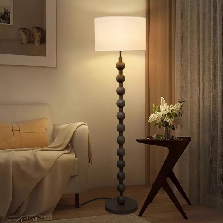 Floor lamp in a living room setting with a couch and side table.